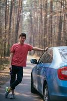 Schöner Mann, der auf der Straße in der Nähe der geöffneten Tür seines Autos steht. foto