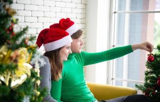 frohe weihnachten und neujahrskonzept. junge kaukasische liebhaberin mit weihnachtsthema kleidung feiern tausch präsentiert sich gegenseitig und redet mit lachen und spaß auf der party zu hause foto