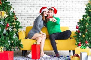 frohe weihnachten und neujahrskonzept. junge kaukasische liebhaber mit weihnachtsthema kleidung feiern und tauschen sich gegenseitig auf der party mit spaß und glück aus foto