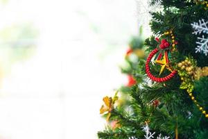 weihnachts- und neujahrsferienkonzept. Nahaufnahme und Unschärfe Christbaumschmuck mit Bändern, Kugeln und Ornamenten über weiße Mauer und Bokeh