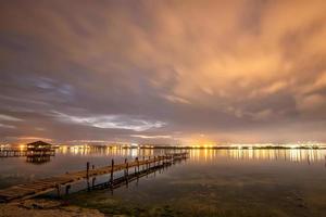 schöne Nachtreflexionen im Meer vom Hafen und sich bewegende Wolken foto