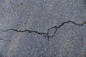 Detailansicht auf Asphaltoberflächen verschiedener Straßen und Straßen mit Rissen foto