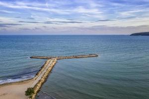 luftaufnahme von meer, küste und wellenbrechersteinen foto