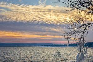 winterseelandschaft, sonnenaufgang oder sonnenuntergang und eiszapfen auf baumzweigen gefroren. foto