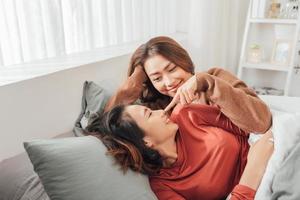 glücklicher gleichgeschlechtlicher asiatischer lesbischer Paarliebhaber im Schlafzimmer foto