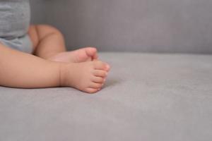 Baby-Kleinkind-Beine auf der Couch foto