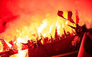 Kroatien, 2022 - Fußball-Hooligans mit Maske, die Fackeln im Feuer halten foto