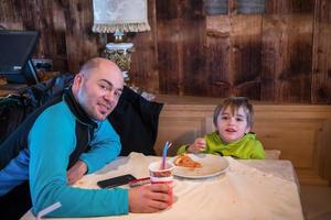 vater sein kleiner sohn isst eine pizza foto