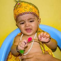 süßes indisches kind, das sich anlässlich des radha krishna janmastami festivals in delhi indien als kleiner lord krishna verkleidet hat foto