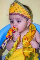süßes indisches kind, das sich anlässlich des radha krishna janmastami festivals in delhi indien als kleiner lord krishna verkleidet hat foto
