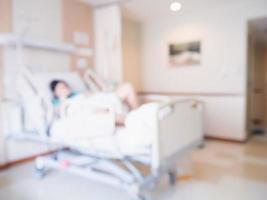 Abstrakter Unschärfepatient auf Bett im Krankenzimmerinnenraum für Hintergrund