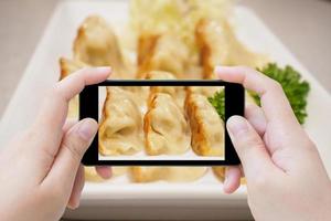 Fotografieren von Gyoza-Knödel mit Smartphone foto