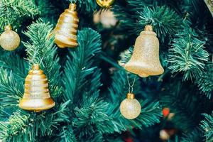 geschmückte goldene glocke am weihnachtsbaum foto