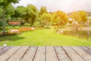 leerer holztisch mit unscharfem gartenpark-natürlichem hintergrund foto