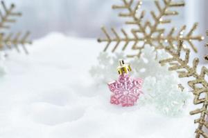 weihnachten des winters - weihnachtskugeln mit band auf schnee, winterferienkonzept. weihnachtsrote kugeln, goldene kugeln, kiefern- und schneeflockendekorationen im schneehintergrund foto
