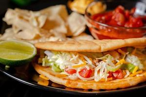 tacos mit mangosalsa und chips. gemischtes mexikanisches essen guacamole, nachos, fajita, fleischtacos. Ansicht von oben. Tex-Mex-Küche. foto