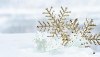 weihnachten des winters - weihnachtskugeln mit band auf schnee, winterferienkonzept. weihnachtsrote kugeln, goldene kugeln, kiefern- und schneeflockendekorationen im schneehintergrund foto