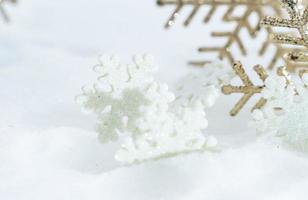 weihnachten des winters - weihnachtskugeln mit band auf schnee, winterferienkonzept. weihnachtsrote kugeln, goldene kugeln, kiefern- und schneeflockendekorationen im schneehintergrund foto