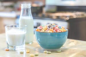 schüssel mit buntem kindermüsli und milch isoliert auf holztisch mit textraum foto