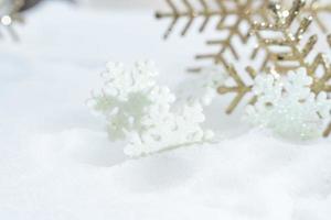 weihnachten des winters - weihnachtsschneeflocken auf schnee, winterferienkonzept. weiße und goldene Schneeflockendekorationen im Schneehintergrund foto