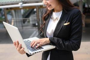 ein schuss der geschäftsfrau, die an ihrem laptop im freien arbeitet foto