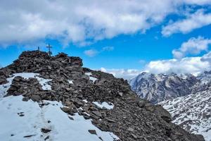 Berggipfel mit Kreuz in den italienischen Alpen foto