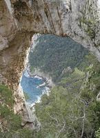 blick hinunter auf arco naturale - ein natürlicher bogen an der ostküste der insel capri foto