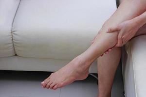 Frau, die an Beinschmerzen leidet. medizinisches und gesundheitskonzept. foto