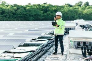 asiatischer junger ingenieur für solarenergie überprüft das produktivitäts-solarmodulfeld zur prüfung foto