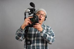 Mann mit HD-Spiegelreflexkamera und Audiogeräten foto
