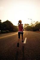 Fitness-Sportfrau des gesunden Lebensstils, die auf Straße läuft. foto