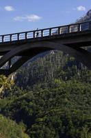 Frau auf einer Brücke, die über ein Tal führt, das durch die wunderschöne Landschaft von Montenegro führt foto