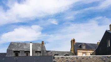 blauer himmel mit weißen wolken über häusern in etretat foto