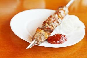 Lammspieß Shishkebab hautnah auf weißem Teller foto