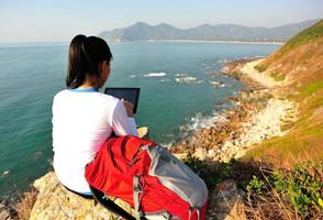 Wanderfrau verwenden Tablet PC am Meer foto