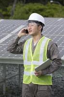 asiatischer Ingenieur überprüft Solarpanel-Setup.