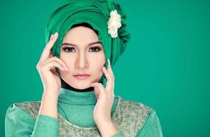 Modeporträt der jungen schönen muslimischen Frau mit grünen Kosten