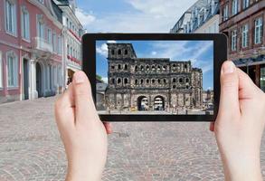 Tourist fotografiert Porta Nigra in Trier foto