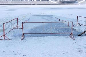 Wintereistauchsport, eine Spur auf dem Wasser von einem Taucher im leeren Eisloch an einem sonnigen, frostigen Wintertag, gesunder Lebensstil foto