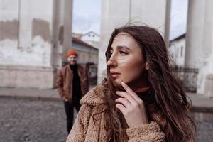 Junge Modepaare, die im Herbst auf der alten Straße posieren. hübsche schöne frau und ihr hübscher stilvoller freund auf der straße am herbsttag foto