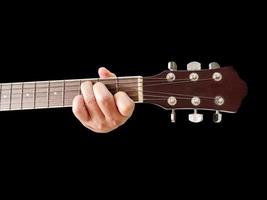 gitarrengriffbrett und gitarrenspieler hand des mannes, die griffbrett hält bild eines griffbretts auf schwarzem hintergrund. foto