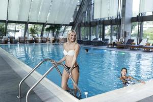 Schöne Frauen, die sich am luxuriösen Pool entspannen. frau im reise-spa-resort-pool. sommer luxusurlaub. Porträt einer schönen Frau in Badebekleidung, die sich im Schwimmbad-Spa entspannt. foto