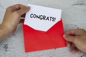 Glückwunschtext auf weißem Notizblock im roten Umschlag. Wertschätzung Konzept foto