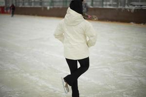 Mädchen auf Schlittschuhen. Winterferien. Eislaufen. sportliche Details. Übung auf Eis. foto