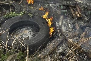 Verbrennen von Müll. illegale Deponie in Brand setzen. Flammen und Rauch. foto