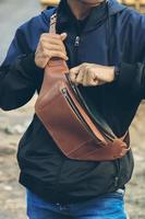 Ledertasche. eine Handtasche oder Umhängetasche aus braunem Leder im minimalistischen Stil oder in einer minimalistischen und luxuriösen Retro-Farbe. foto