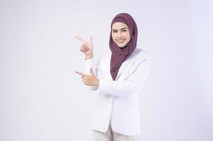 Schöne muslimische Geschäftsfrau mit weißem Anzug und Hijab im Studio foto