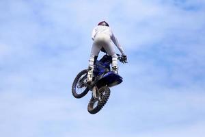 Biker macht mit seinem Dirtbike einen Freestyle-Trick foto