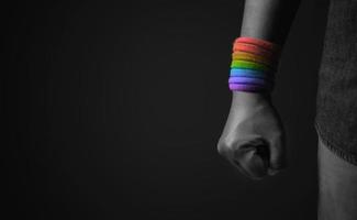 macht, protest und ausdruck für lgbtq, rechtekonzept. Nahaufnahme von Faust und Regenbogenarmband. wütend, bereit zu schlagen. beschnitten und selektiver Fokus foto