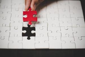 Geschäftsfrau-Personenhand mit Puzzleteilidee für Strategie und Lösung. Closeup Teil von zwei weißen Puzzles verbinden sich. konzept des gemeinsamen zusammenarbeitserfolgs teamwork-problem unternehmensteam. foto